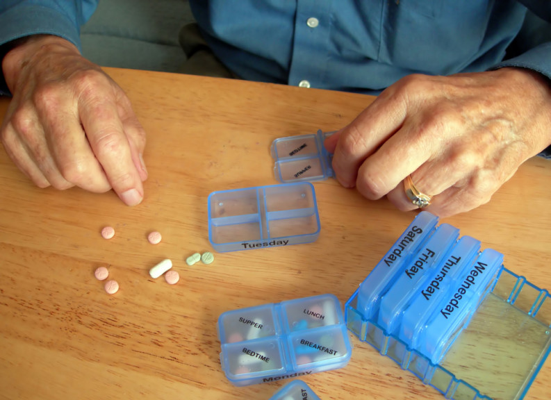 Elderly man sorting pills
